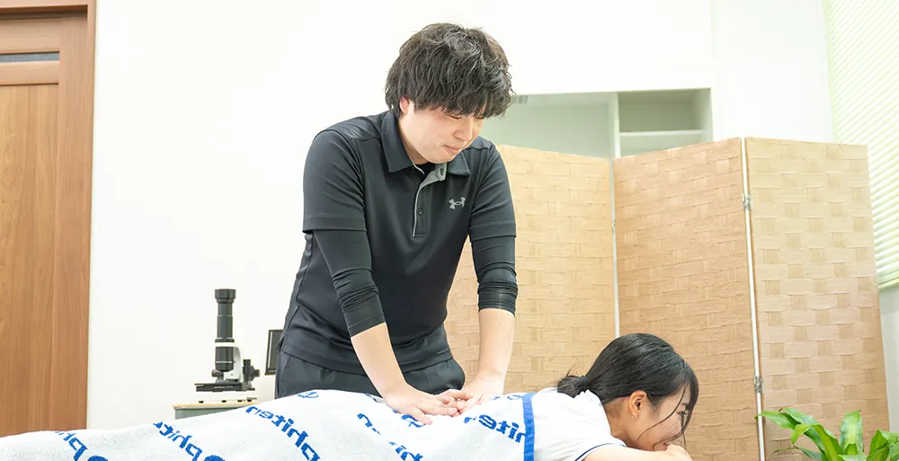 背中の整体を行う整体師